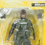 窓部分の上半分のクローズアップ。本体の上半身と、交換用の手首パーツおよびハンドガンが見える。