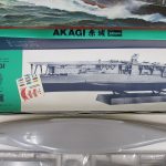 船体パーツと台紙。灰色の船体が袋から出された状態です。