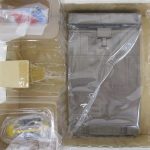内箱の仕切りと、灰色の台座パーツ、袋入りの小型メカ。