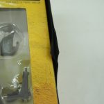 窓越しに見える付属品のクローズアップ。銃器パーツがブリスターに収まっている。