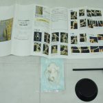 説明書と付属品。台座と支柱、袋入りの小物が並びます。