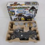 DXトライドベンダーの外箱と、緩衝材に収まった本体、メダルを並べたところ。