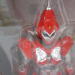 窓越しに本体の頭部と胸を寄って撮影。赤い装甲の造形が分かる。