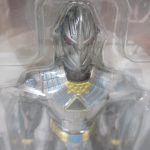 窓越しに見える本体上半身のクローズアップ。銀色の装甲と金色の装飾。