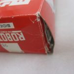 外箱の角のクローズアップ。角がつぶれ、破れが見られる。