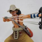 上半身を寄って撮影。パチンコを構えた姿勢と表情が分かる。