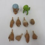 交換用の頭部、手のパーツ、緑色の人形を並べて撮影。