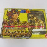 聖闘士聖衣大系 レオクロスの外箱表面。黄色地に獅子座の聖衣が描かれている。