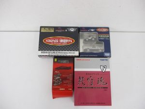 同じ出品の4箱を並べて撮影。左上の黒い箱が本商品のトミカ&チョロQ 1周年記念モデルです。