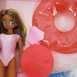 内箱の本体と付属パーツ。ピンクの水着を着用し、浮き輪などが同梱されています。