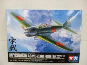 タミヤ 1/32 零式艦上戦闘機五二型の外箱正面。雲の上を飛ぶ零戦のイラストです。