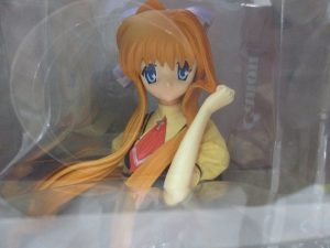 窓越しに撮影した本体の上半身。オレンジ色の長い髪の造形です。