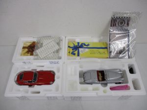 発泡スチロールの台座に収まった2台と付属品。右の銀色の車が本商品の 1952 Jaguar XK120 です。