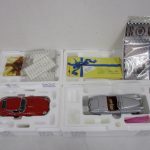 発泡スチロールの台座に収まった2台と付属品。左の赤い車が本商品の 1961 Jaguar E-Type Coupe です。