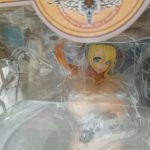 窓越しに見えるフィギュアの上半身と透明トレイ
