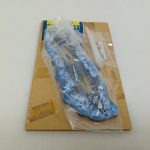 袋に入った本体と台紙を縦に置いて写した写真