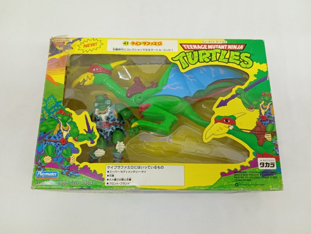 外箱の正面。窓からケイブラファエロと翼竜のフィギュアが見え、TURTLESのロゴ