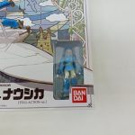 商品箱の正面右側の拡大。窓の中のナウシカのフィギュアとBANDAIのロゴ