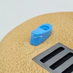 台座の上の青いサンダルと排水口の造形