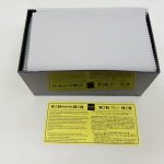外箱に保護シートがかかった状態と黄色い注意書きの紙