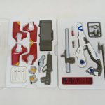 ブリスターのトレイに収まった武器や交換用の手、白い銃、EVANGELIONのロゴが入ったプレート