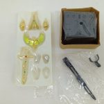 ブリスターに入った杖や頭部パーツなどの付属品と、箱に入ったディスプレイ台