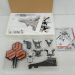 中身を並べた写真。トレイに入った機体、台座、パーツ、説明書