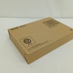 輸送箱を斜めから撮った写真。ロゴとバーコードのある面と側面が写っています。