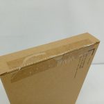 輸送箱を側面から写した写真。平たい箱で、上面に透明フィルムの反射があります。
