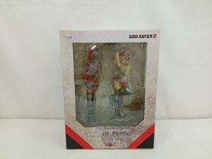 外箱の正面。透明窓の中に赤い衣装のフィギュアが立ち、下部に「GOD EATER 2」のロゴと商品名が印刷されています。