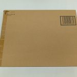 輸送箱を斜めから見た全体。右上にバーコード、左端は側面のテープ留め部分。