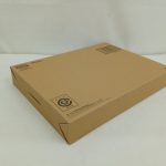 輸送箱を斜め上から見た全体。上面にバーコードとダンボールの注意書きの印字。