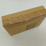 輸送箱を斜め上から撮った写真。上面と側面、貼られたテープが写っています。