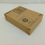 輸送箱を斜めから撮った写真。ロゴとバーコードのある面と側面が写っています。