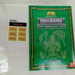 緑色の取扱説明書と、注意書きの紙、黄色いシールの台紙が並べてあります。