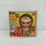 外箱の正面。「超合金 GB-04 ガチャガチャ ドラえもん ポピー カプセル12コ入」の印字と、窓から見える本体。