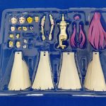 青い布の上に置いた透明トレイ。顔の部品、手、髪の部品、白いスカート4枚