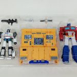 透明トレイに入った本体を上から撮った写真。白と赤のロボット、黄色い基地、武器が並んでいます。