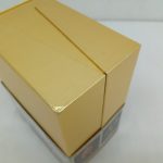 金色の箱を斜め上から撮った写真。上面と側面が写っています。