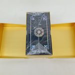 金色の箱を開けた状態。中に黒い小箱が袋に包まれて入っています。