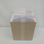 外箱の上面。プチプチ越しに、白い上面とテープ留めの部分が写っています。