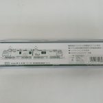 透明ケースの裏面。車両の線画、仕様の説明、バーコード、「関水金属」の表示があります。
