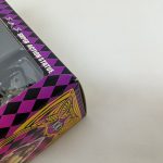 外箱の角のアップ。「SUPER ACTION STATUE」の文字と透明窓の縁が写っています。