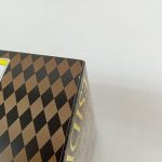 外箱の角のアップ。菱形模様と、注意書きラベルの一部が写っています。