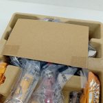 仕切りの下の中身。袋に入ったオレンジや赤のパーツが並んでいます。