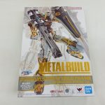 商品の外箱の正面。金色の機体の絵と「METAL BUILD」「GUNDAM ASTRAY GOLD FRAME (ALTERNATIVE STRIKE Ver.)」の文字があります。
