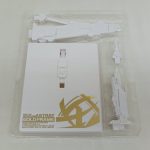 透明トレイに入った白い台紙と大型のパーツが写っています。