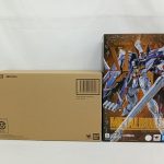 輸送箱と外箱を並べた写真。外箱の正面に機体の絵と「METAL BUILD」の表記があります。