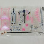 透明トレイに入ったピンク色のエフェクトパーツと、細かい武器パーツ。