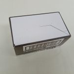 外箱の底面。白い面とテープ、側面のバーコードの一部が写っています。